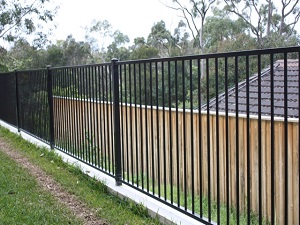 черный металлический забор на бетонной основе